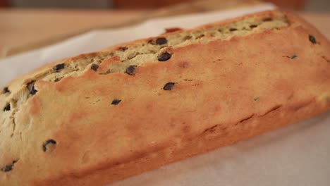 Primer-Plano-De-Pan-Casero-Con-Trocitos-De-Chocolate,-Encienda-El-Fondo-De-Madera