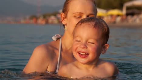 Glückliche-Mutter-Wirft-Ihren-Sohn-Ins-Meer