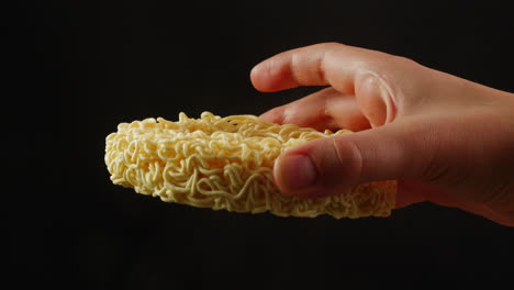 hand holding a block of instant noodles