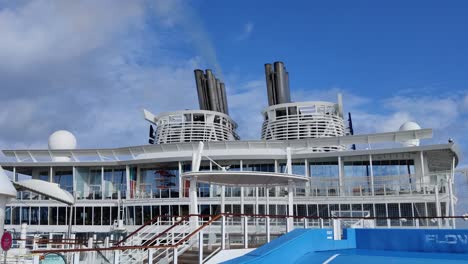 enorme chimenea de barco de cruceros o embudo de humo con un humo ondeando en el cielo de fondo de vídeo | una chimenea de cada dos en un crucero con humo saliendo hacia el cielo-1