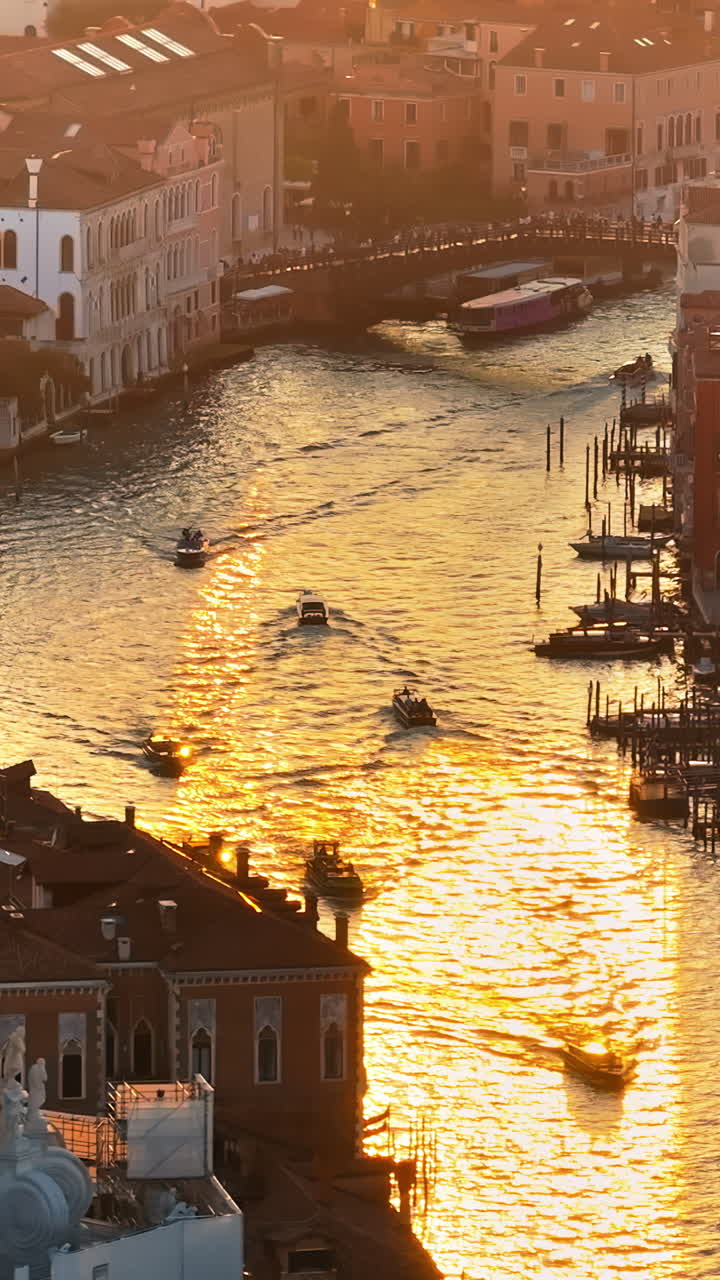 Aerial drone view of boats moving through Venice City, Italy at sunset. Vertical