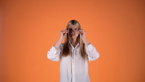 Hermosa-Mujer-Rubia-Con-Gafas-Y-Gesto-De-Saludo-Con-La-Mano,-Foto-De-Estudio-Colorida