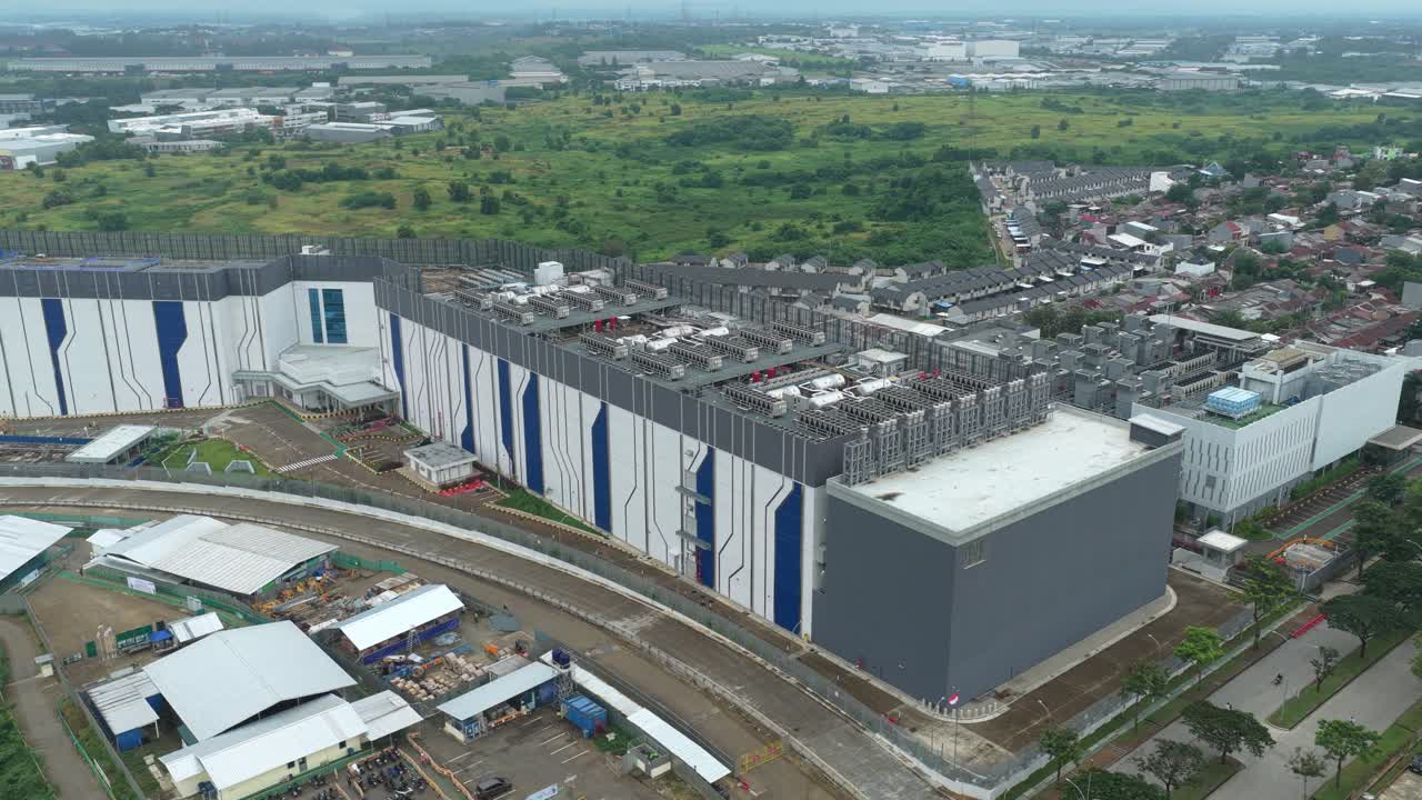 Luftfoto af en stor, moderne datacenterbygning. Dette anlæg repræsenterer moderne teknologiinfrastruktur og digital lagring.