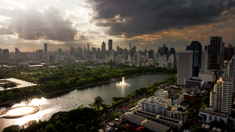 benchakitti forest park with lake in downtown bangkok, drone skyline sunset view