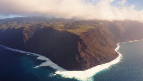 antena: gigantesca costa de la isla de madeira con olas rompiendo y paisaje iluminado