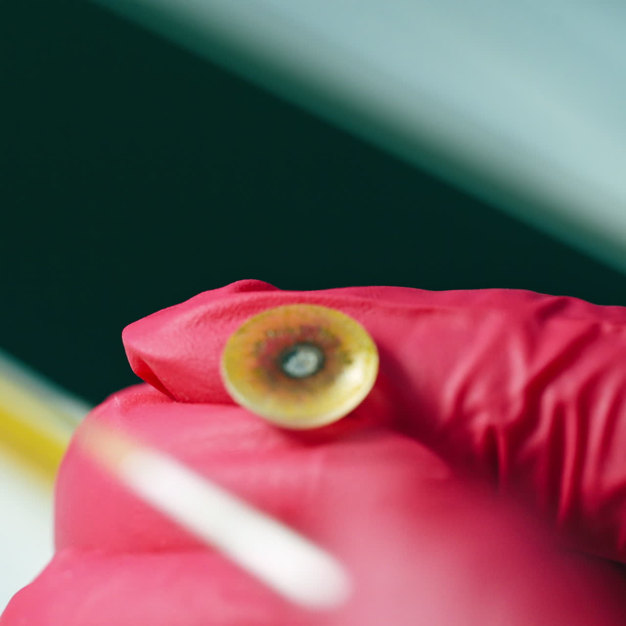 Medical technician making eye prosthesis. Plastic prosthetic eye producing by laboratory worker. Close-up.