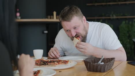 couple eating pizza at a restaurant