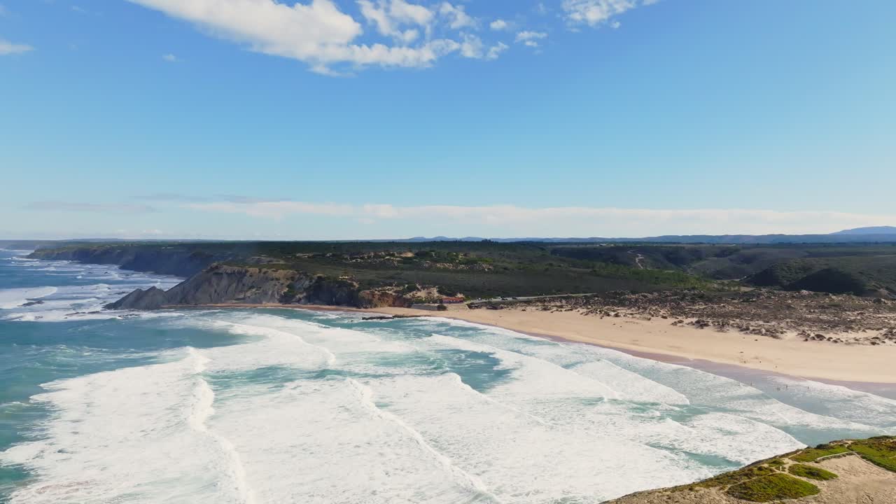 High Aerial view of a drone coming showcasing a beach with its magnificent Portugal coastline with its splendid waves