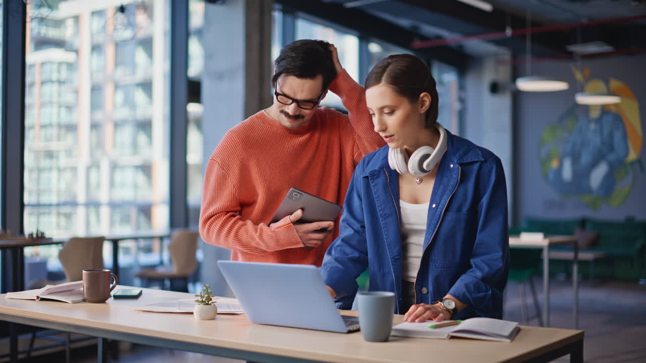 Two entrepreneurs brainstorming business startup looking computers in office
