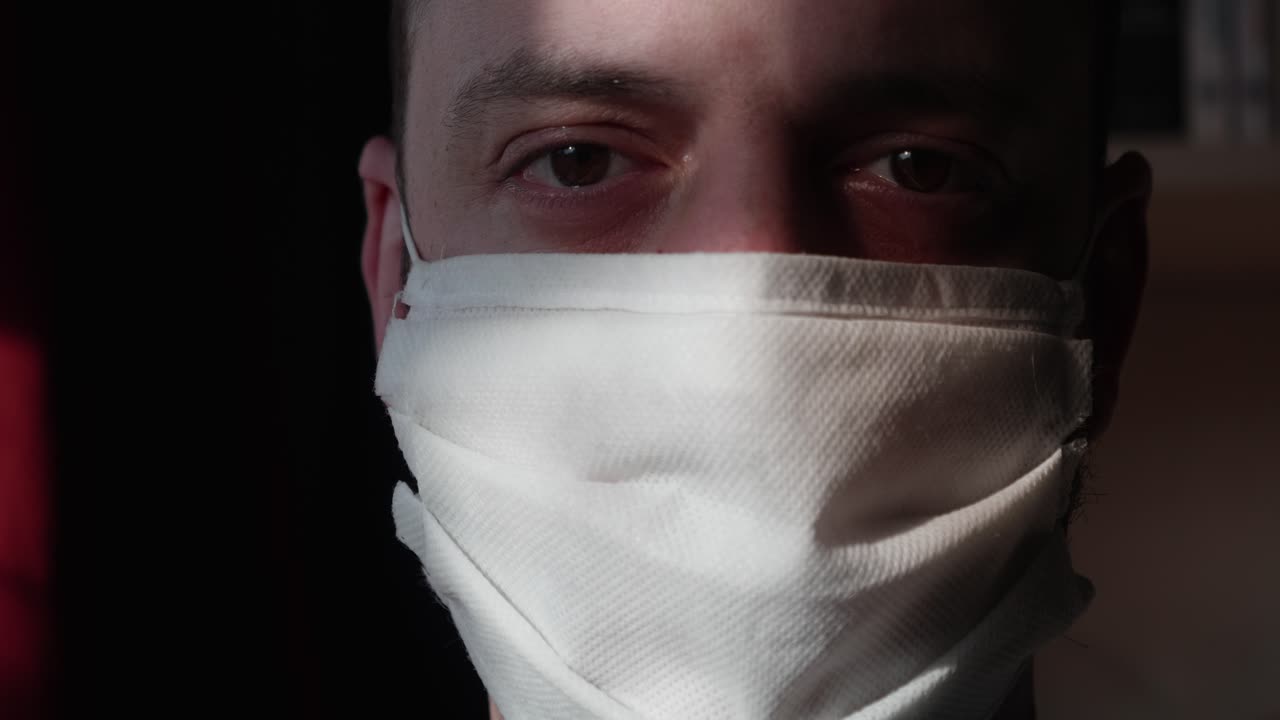 Hombre se pone mascarilla blanca para protección