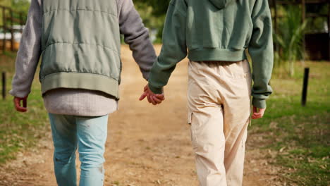 back of couple, holding hands