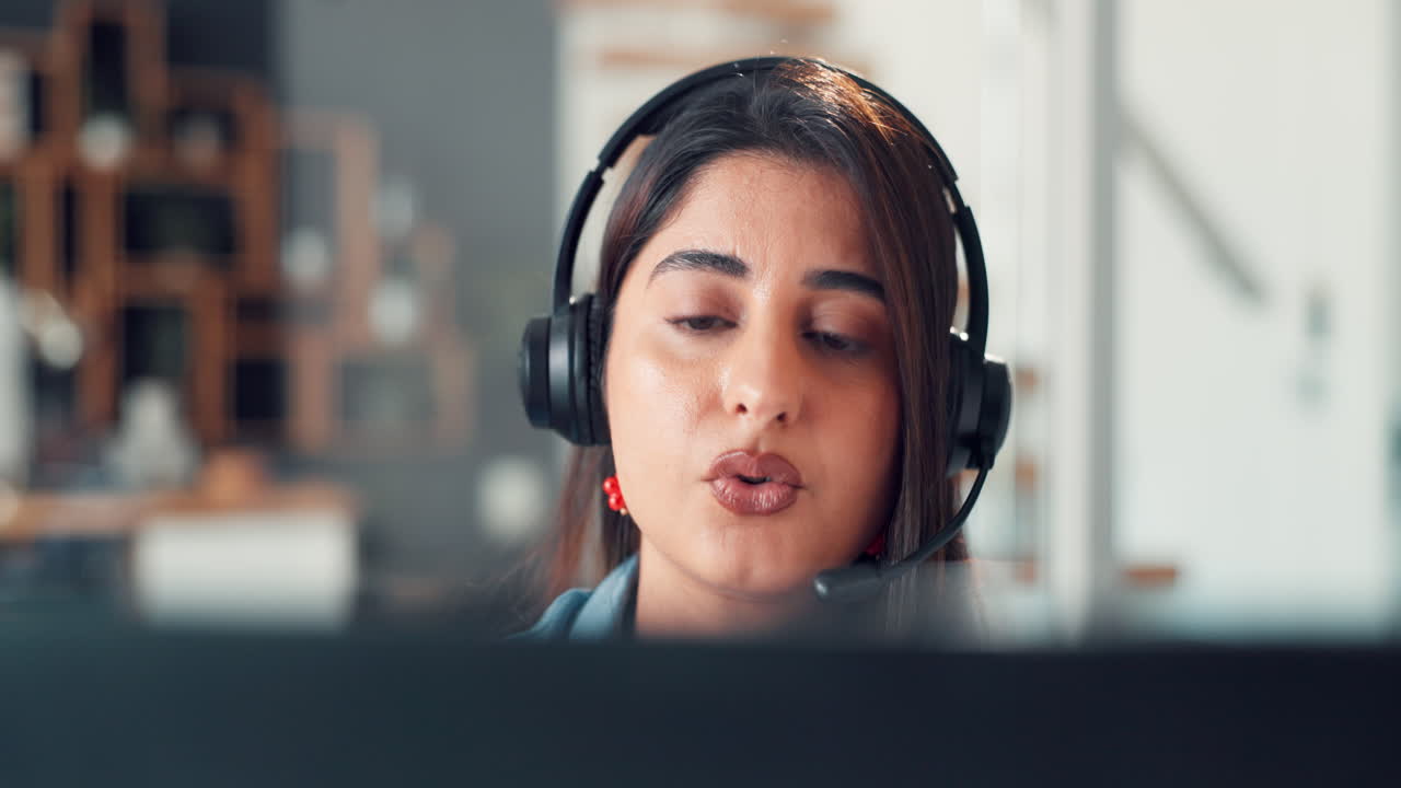 Ung kvinne med headset som snakker i et kundesenterkontor