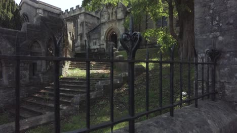 Panning-through-an-old-wrought-iron-fence-at-a-12th-century-church-in-England