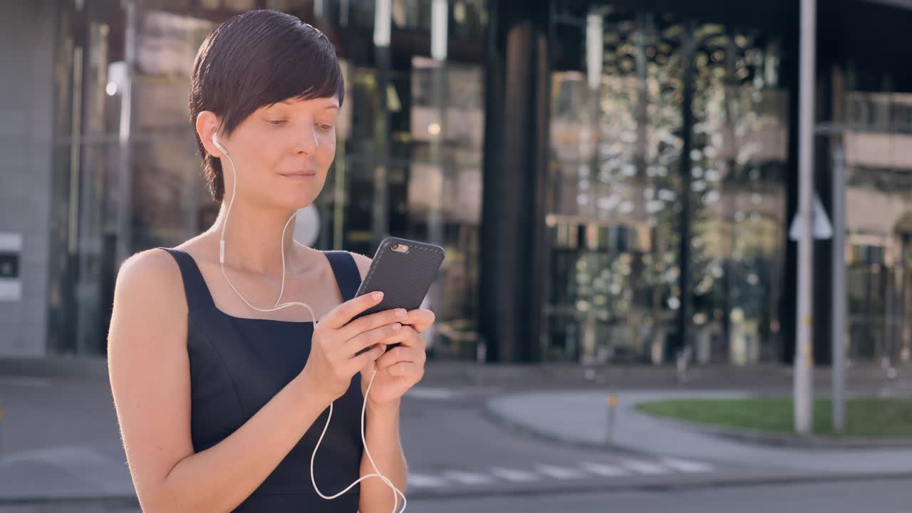 dama con vestido elegante enviando mensajes de texto al aire libre