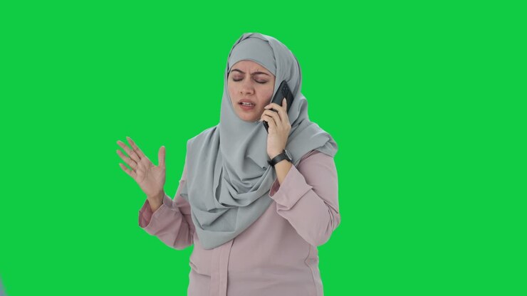 Angry Muslim businesswoman shouting on phone Green screen