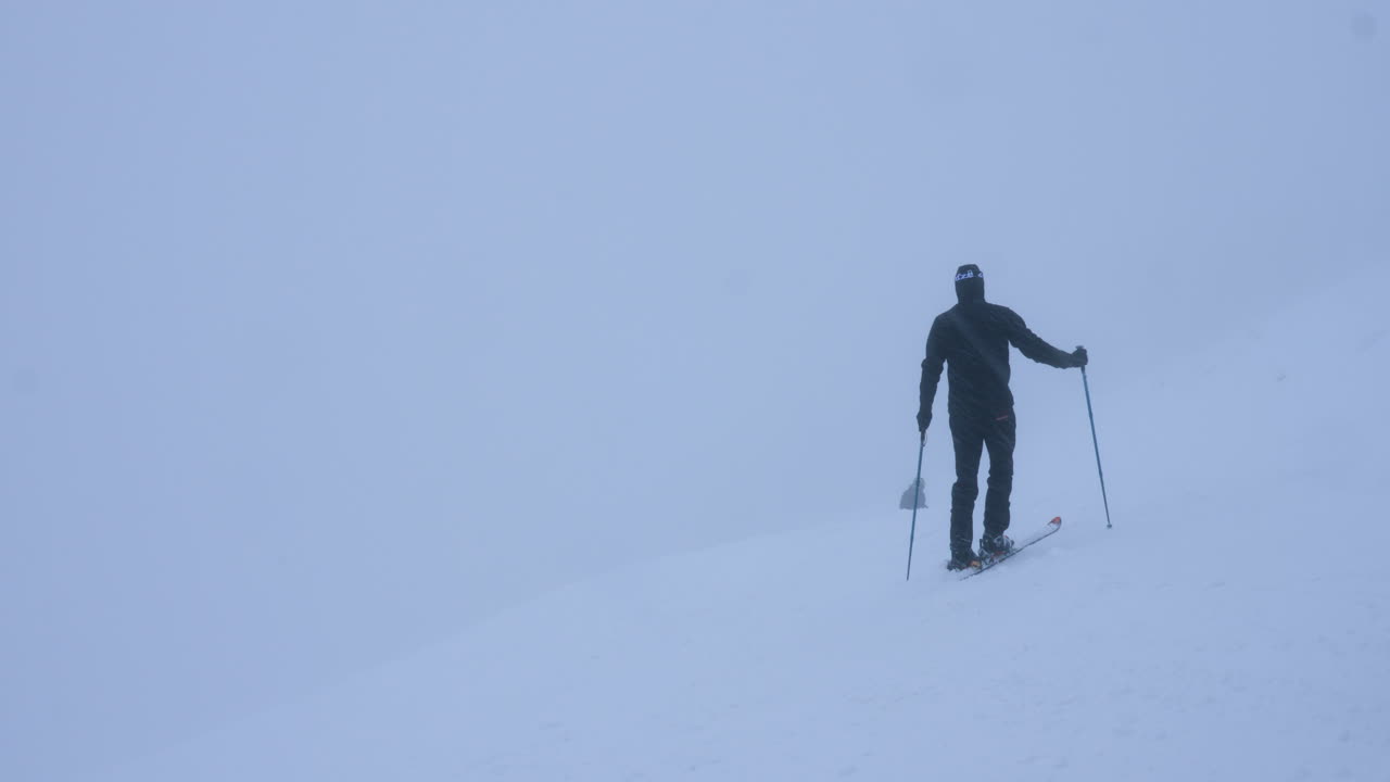 Man skiing in foggy snowy mountains