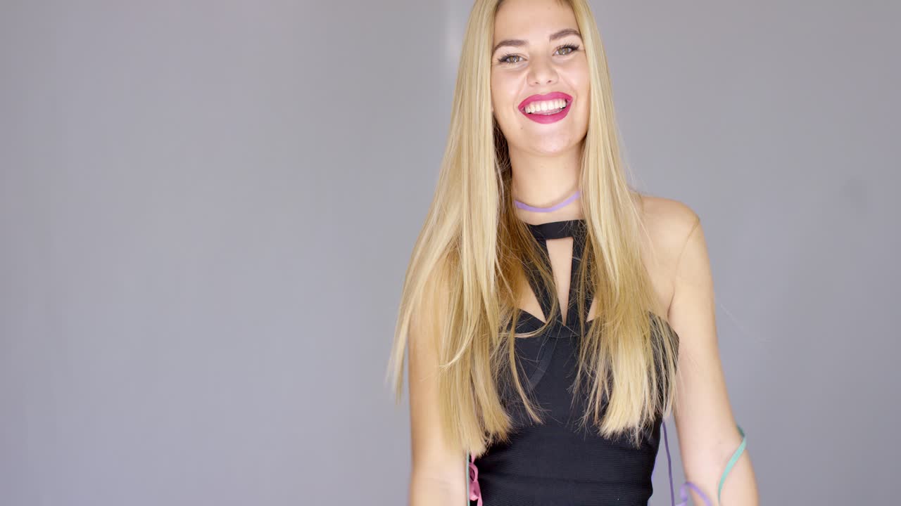 chica rubia sexy soplando confeti a la dirección de la cámara