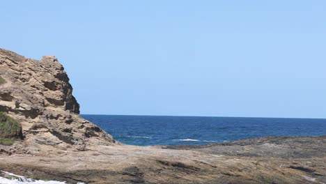 waves hitting rocks on a sunny coastline