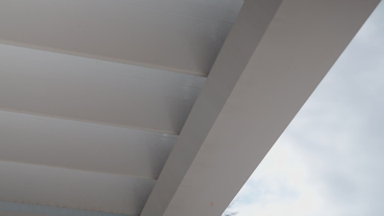 disparo lento revelador de una casa pérgola afuera en el jardín bajo una luz dura