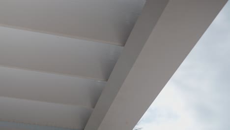 slow revealing shot of a house pergola outside in the garden under harsh light