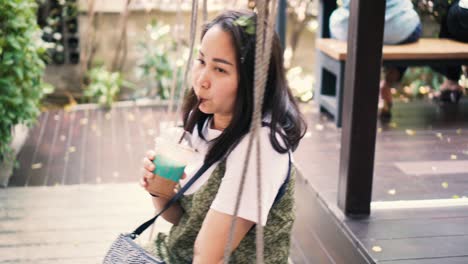 woman drinking coffee on a swing