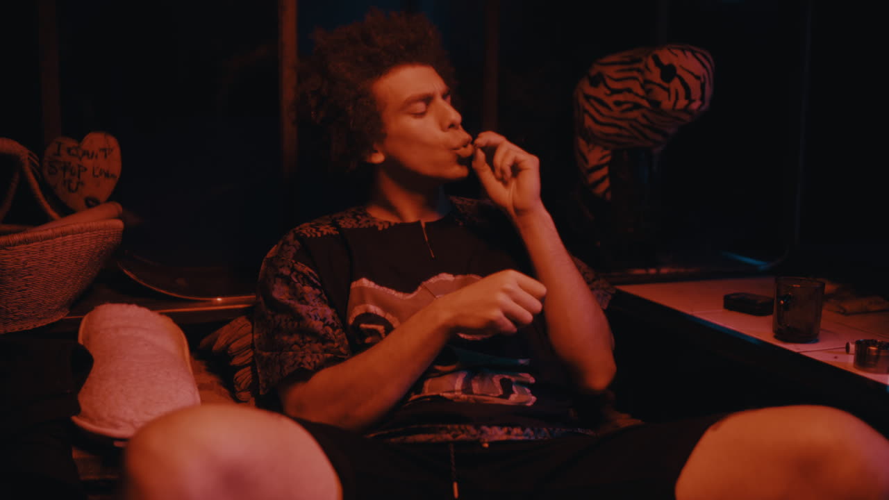 Young Man Smoking in a Dark Room