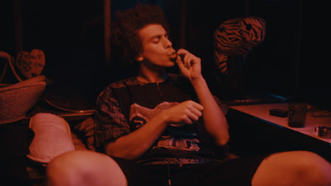 young man smoking in a dark room