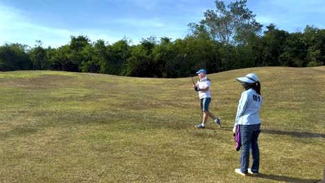 el practicante de golf se balancea con el caddy observando