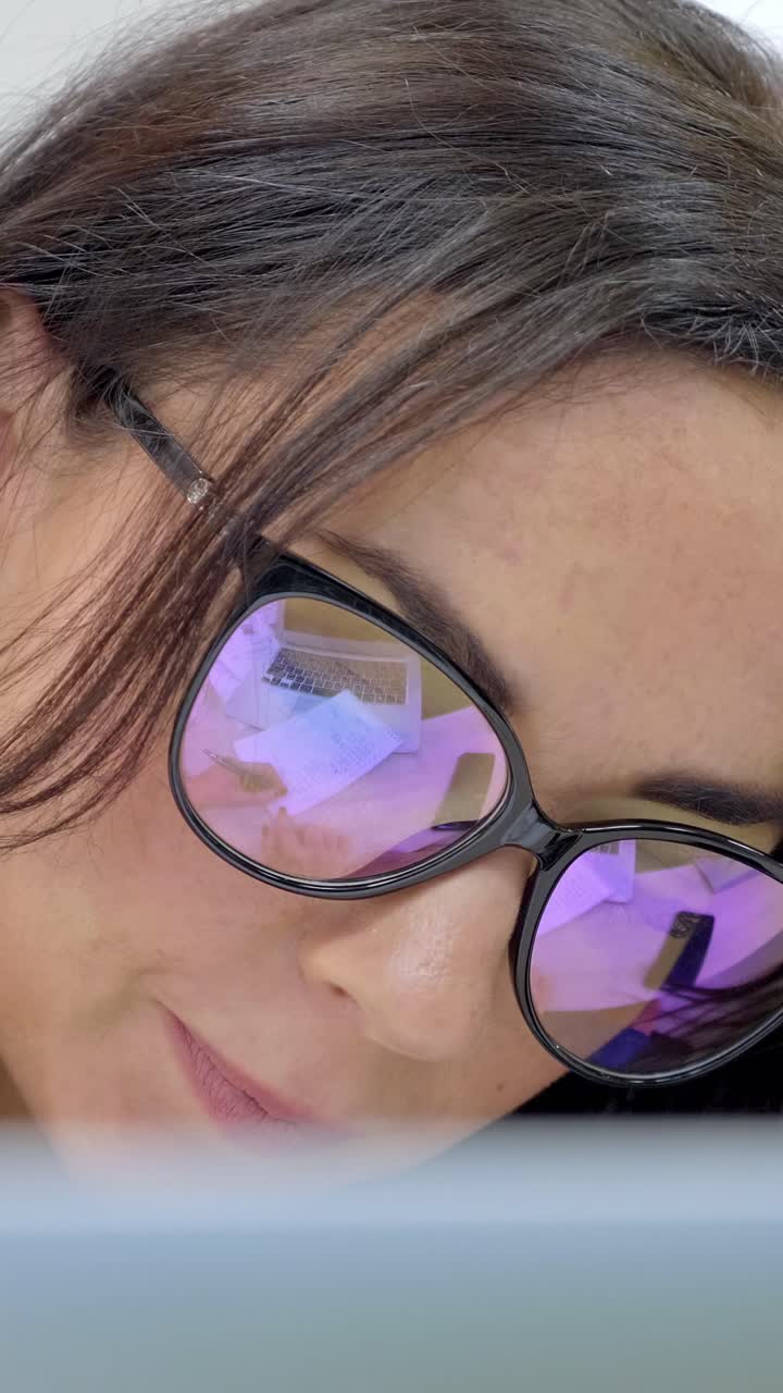 mujer con gafas mirando hacia abajo