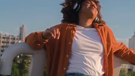 disparo ancho de mujer negra con auriculares y bailando en el puente