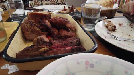 south american dining table serves asado, barbecue with wine, bread, traditional cuisine
