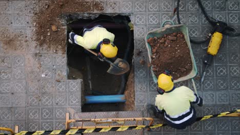 Vista-Superior-De-Los-Trabajadores-Constructores-Cavando-Palas-Y-Rompiendo-Un-Hormigón-En-Una-Calle-De-Barcelona-En-Cámara-Lenta