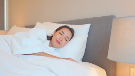 beautiful young asian woman sleeping well in comfortable bed of hotel bedroom