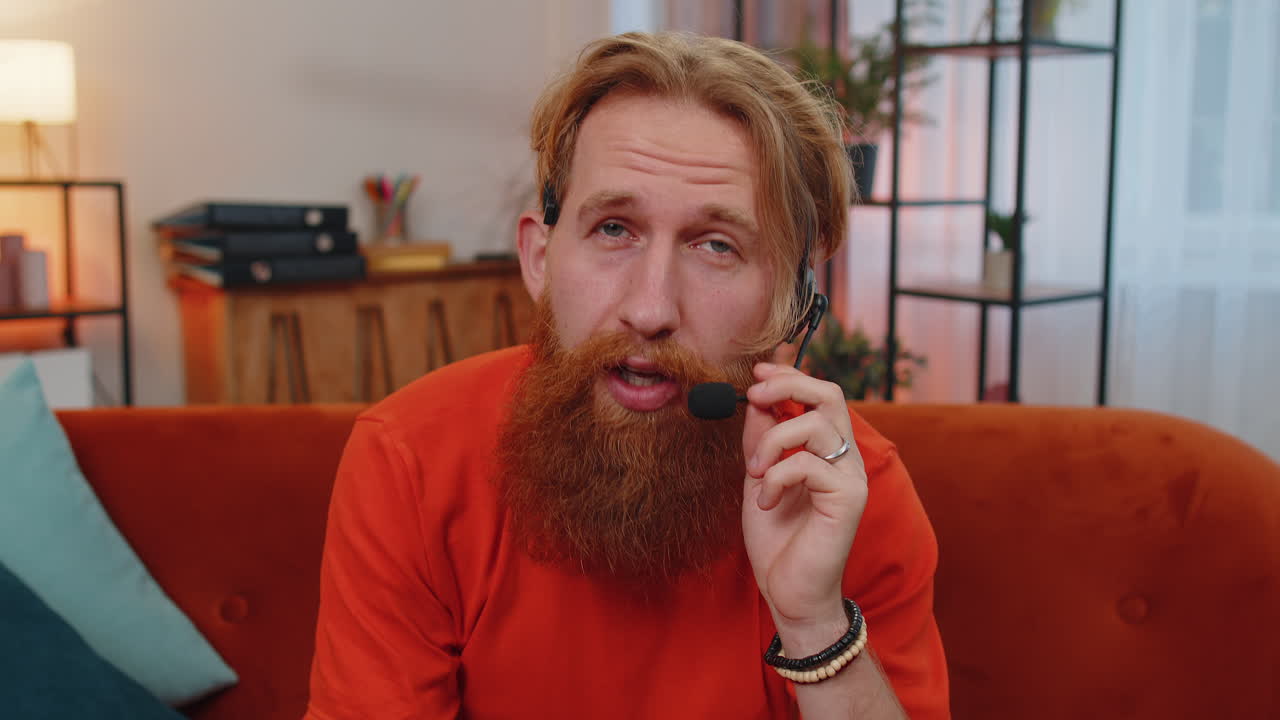 hombre barbudo trabajador independiente centro de llamadas, operador de servicio de apoyo línea de ayuda hablando con el cliente