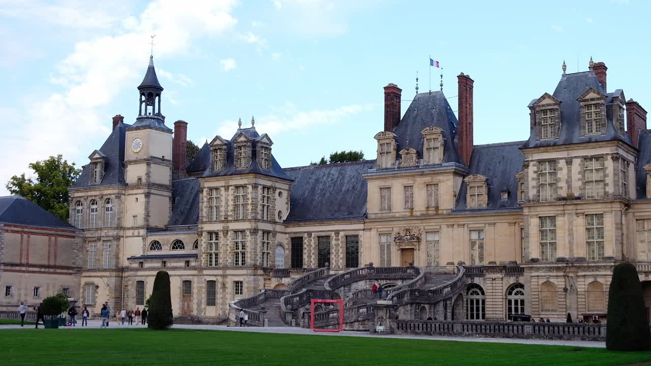 Fontainebleau, France - April 21, 2021: People walking in front of the Chateau de Fontainebleau castle in daylight