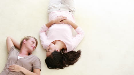 una pareja de lesbianas tendida en el suelo.