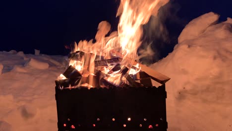 la leña apilada en la parrilla arde bien y brillantemente por la noche.