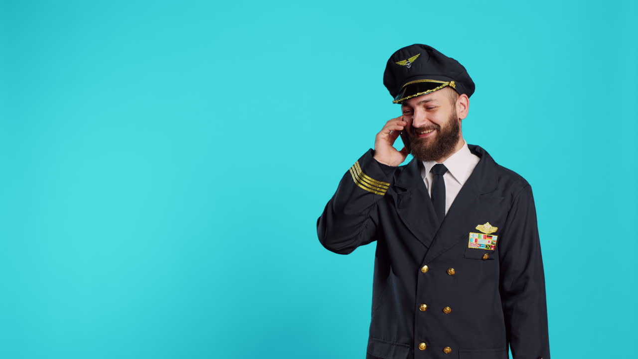Aviatore che parla al telefono con uno smartphone e ride