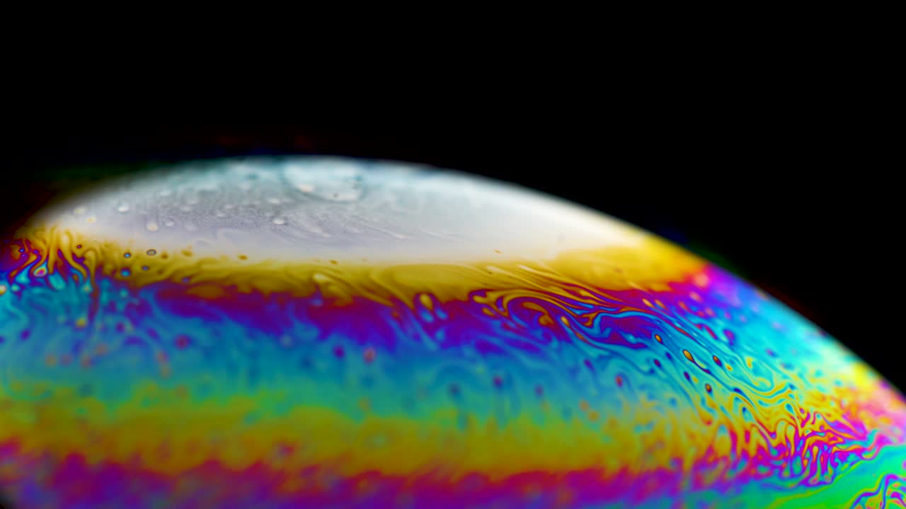 planeta abstracto psicodélico de una burbuja de jabón, refracción de la luz en una burbuje de jabón. macro de primer plano en la burbuja del jabón. colores del arco iris en un fondo negro. modelo de espacio o planetas universo galaxia cósmica.