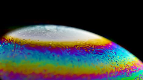 planeta abstracto psicodélico de una burbuja de jabón, refracción de la luz en una burbuje de jabón. macro de primer plano en la burbuja del jabón. colores del arco iris en un fondo negro. modelo de espacio o planetas universo galaxia cósmica.