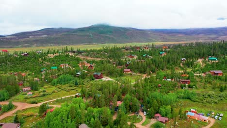 mountain village surrounded by pine tree forest and rolling hills in the rocky mountains on a cloudy summer day