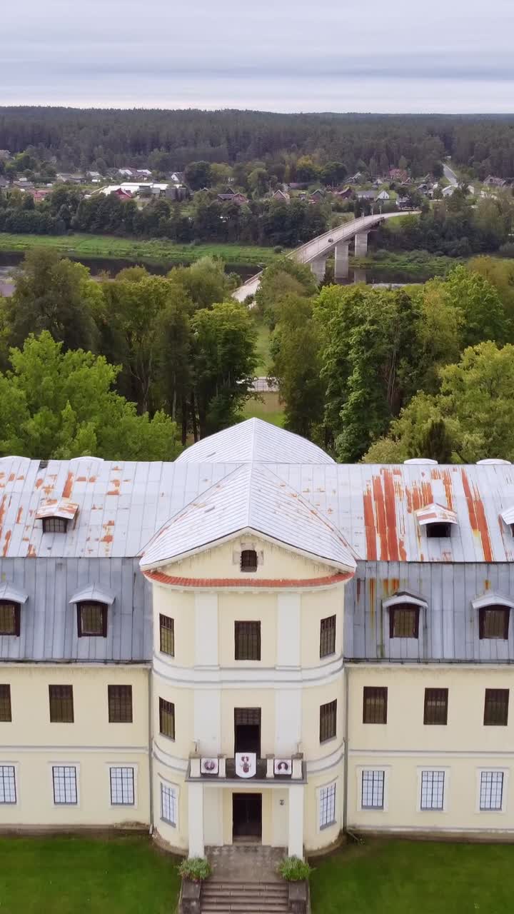 Kraslava Bridge And New Palace, Landmark Buildings, 19th Century Architecture, Travel, History, And Tourism In Latgale, Latvia. Vertical Drone Reverse Over Building Exterior.