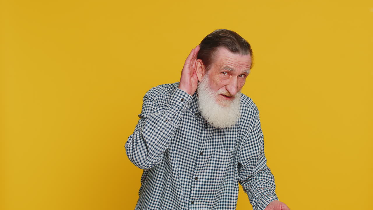 Senior old man trying hear you looking confused and frowning keeping arm near ear for louder voice