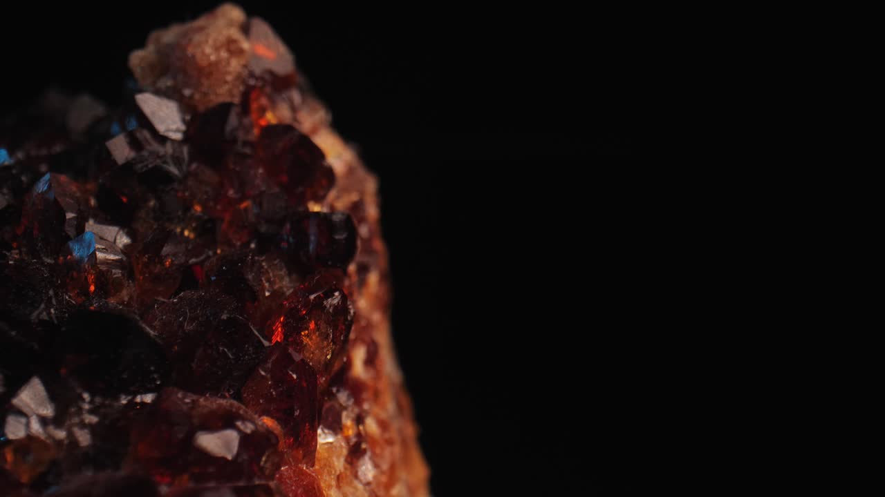 Detailed shot of a golden citrine crystal aglow against a dark background