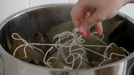 cooking zongzi food - preparing and steaming chinese rice dumpling.