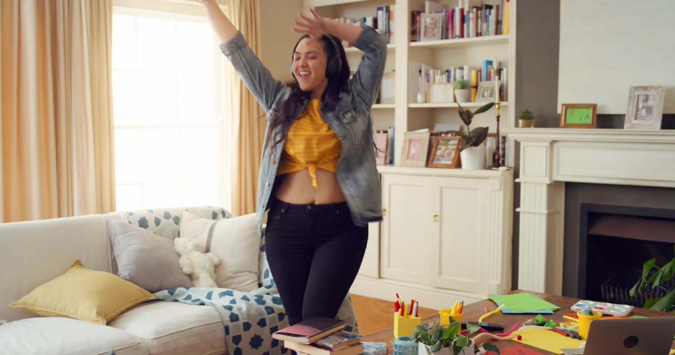 Young Woman Dancing and Listening to Music in Living Room