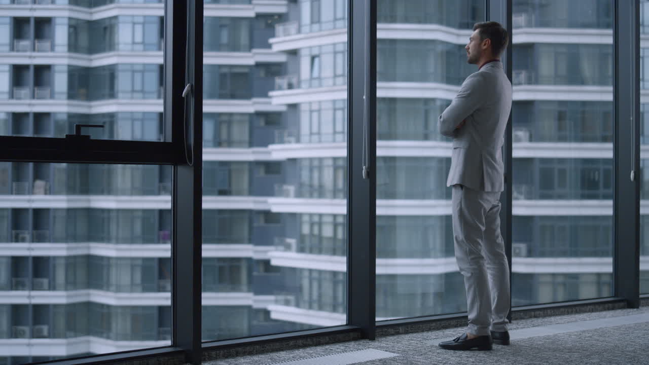 Successful businessman looking out window