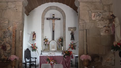 serene altar setup in a stone chapel with a crucifix and flower arrangements