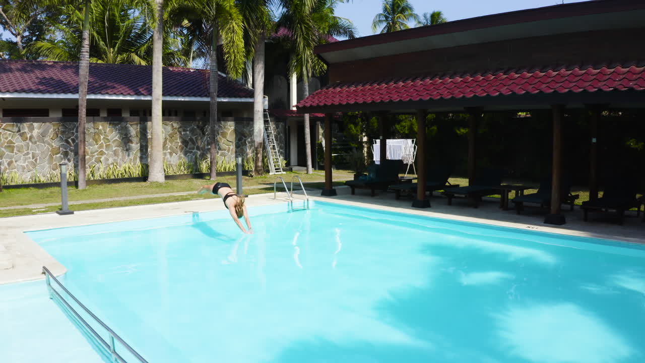 Person Swimming in a Tropical Resort Pool