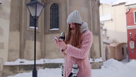 Traveler-woman-holding-mobile-phone,-chatting-with-friends-and-family,-drinking-hot-drink-tea